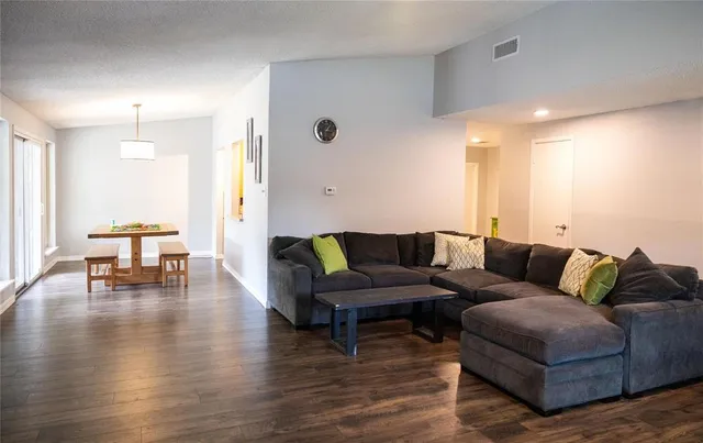 a living room with furniture and a wooden floor