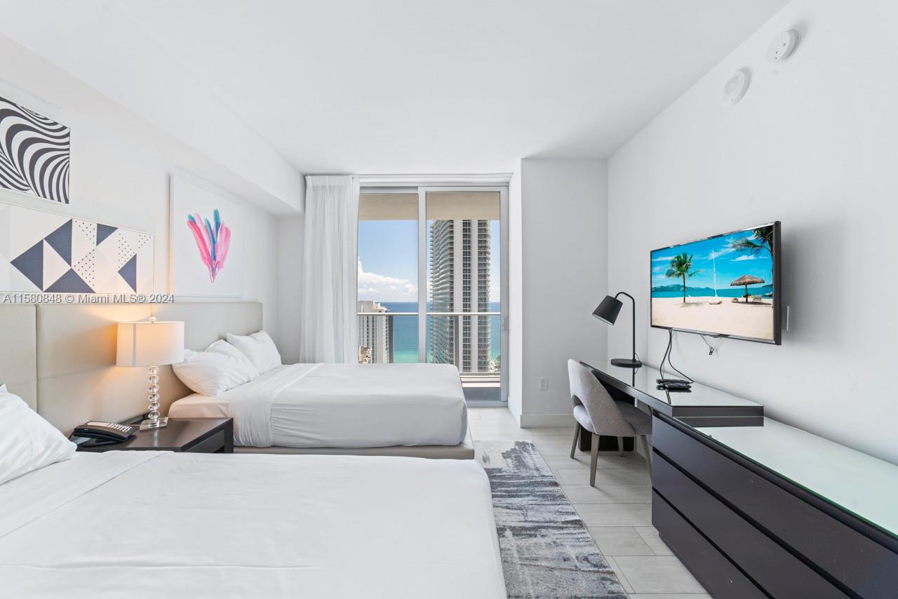 4010 South Ocean Drive, Unit R2505 Hollywood, FL 33019 - Photo 11 of 25 a bedroom with a bed and a desk