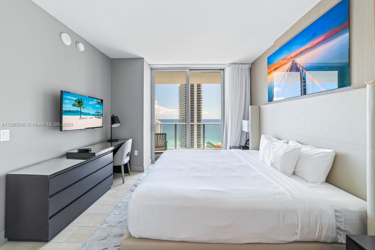 4010 South Ocean Drive, Unit R2505 Hollywood, FL 33019 - Photo 15 of 25 a bedroom with a bed and a flat screen tv