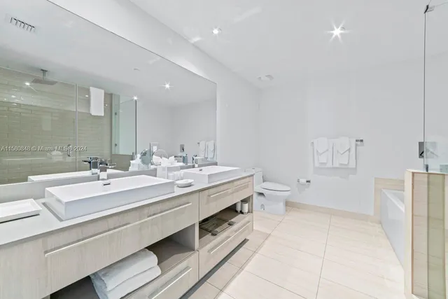 a spacious bathroom with a double vanity sink mirror and toilet