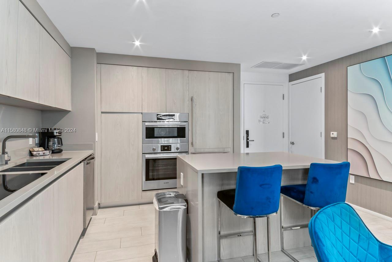 4010 South Ocean Drive, Unit R2505 Hollywood, FL 33019 - Photo 24 of 25 a kitchen with stainless steel appliances a sink a stove a refrigerator cabinets and dining table