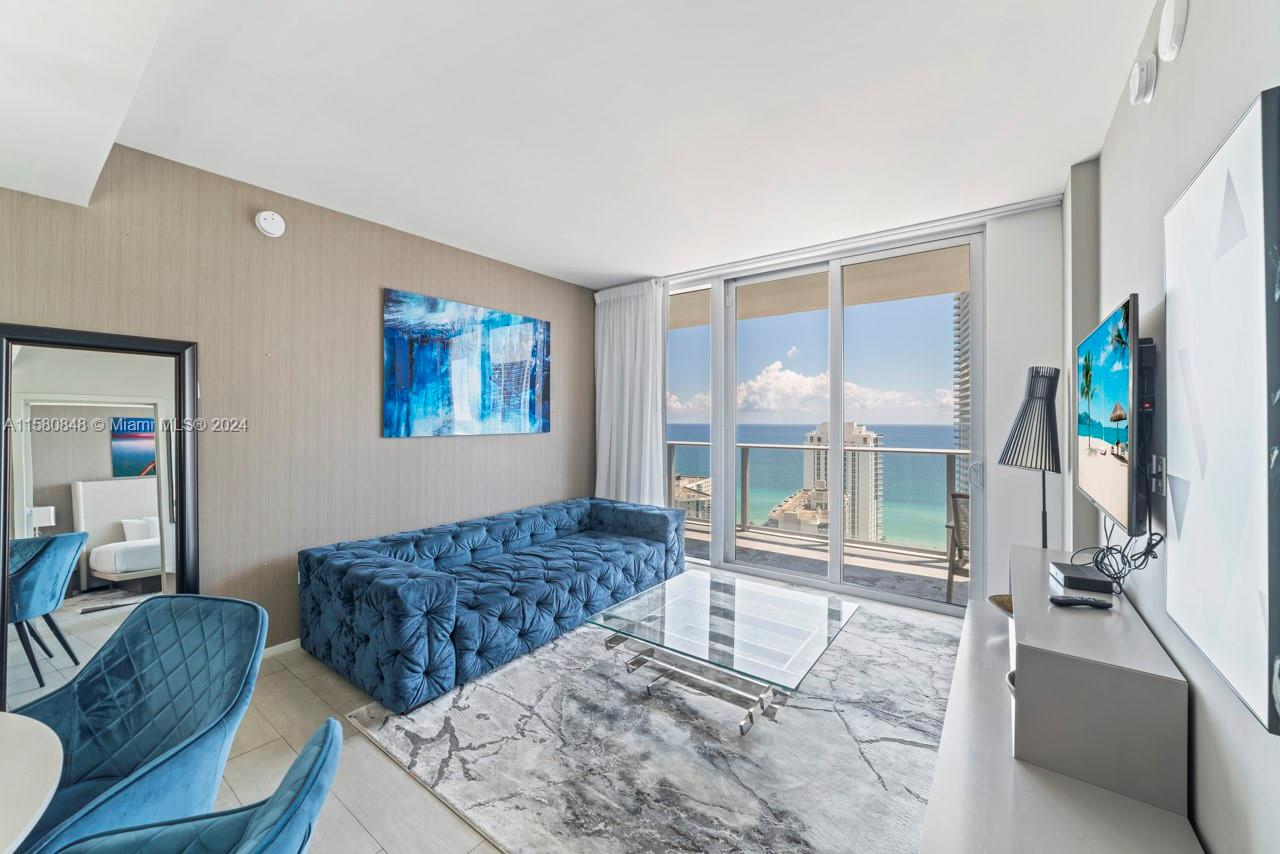 4010 South Ocean Drive, Unit R2505 Hollywood, FL 33019 - Photo 5 of 25 a living room with couches a coffee table and a flat screen tv