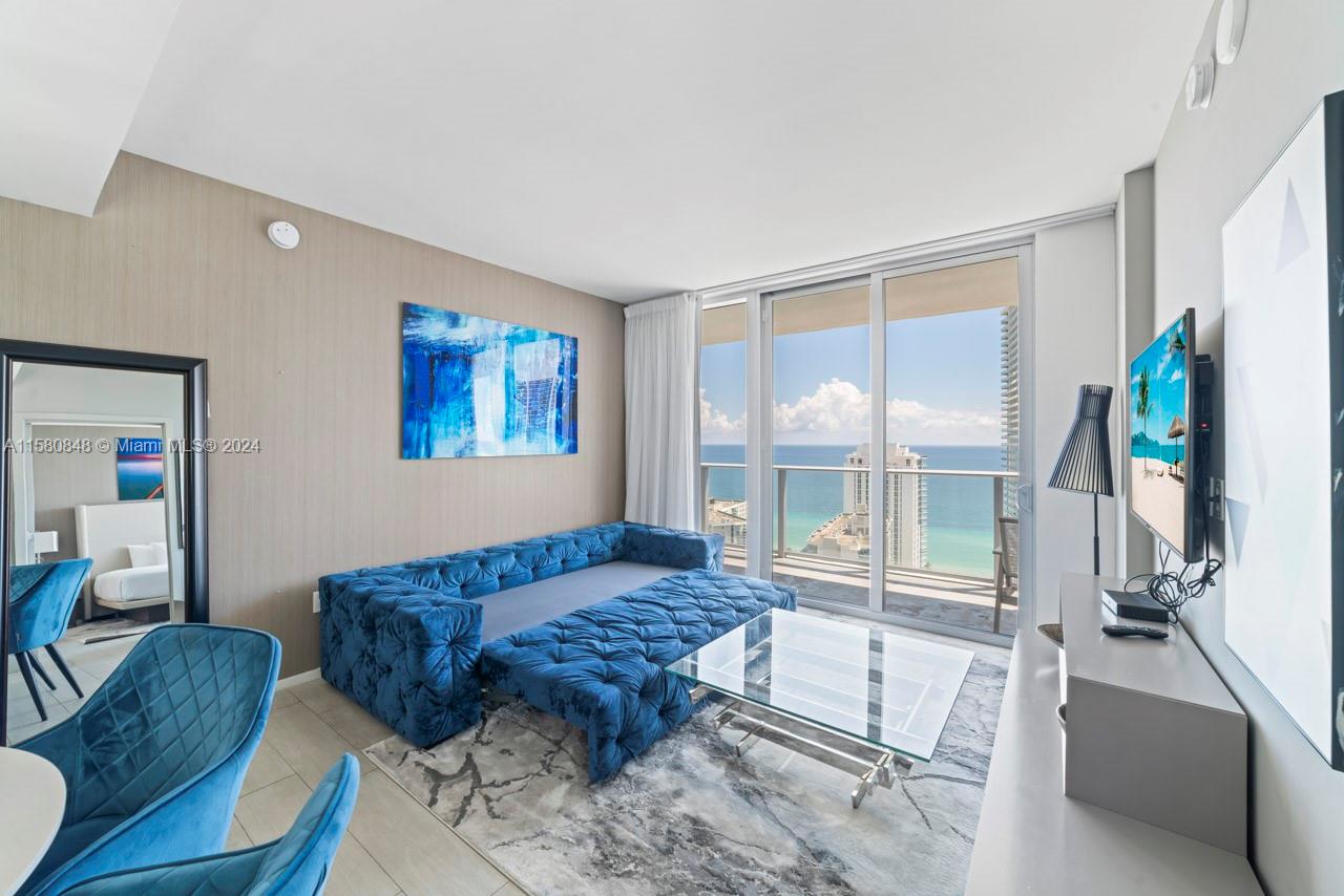 4010 South Ocean Drive, Unit R2505 Hollywood, FL 33019 - Photo 6 of 25 a living room with couch a rug and a flat screen tv