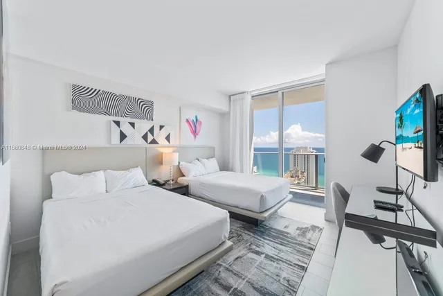 a bedroom with two beds and a large window