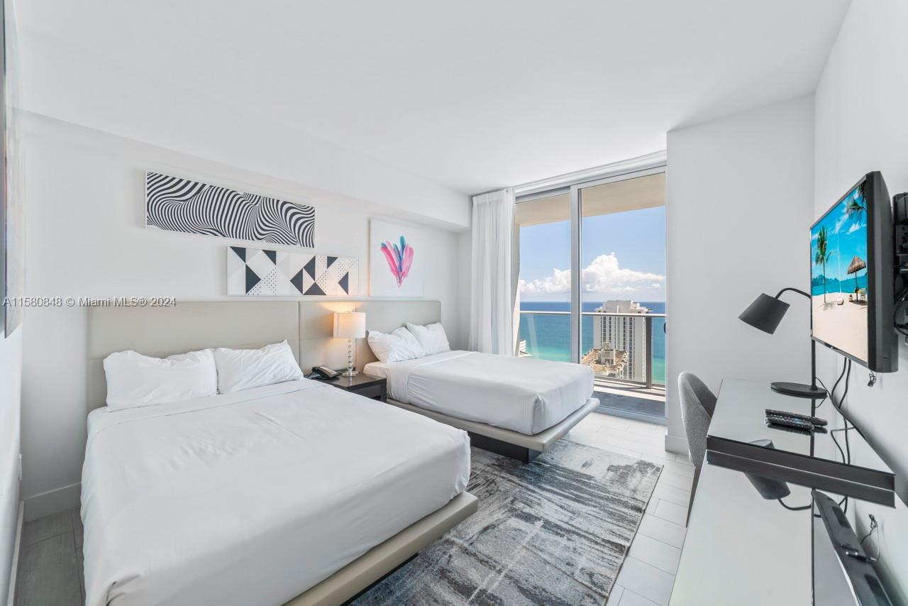 4010 South Ocean Drive, Unit R2505 Hollywood, FL 33019 - Photo 10 of 25 a bedroom with two beds and a large window