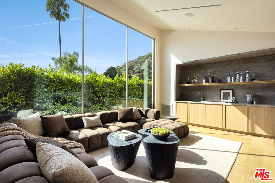 1600 Rising Glen Road Los Angeles, CA 90069 - Photo 17 of 28 a living room with furniture potted plant and a large window