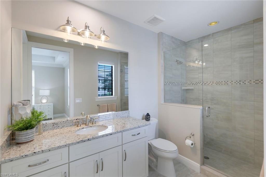 16445 Carrara Way, Unit 202 Naples, FL 34110 - Photo 15 of 35 a bathroom with a granite countertop sink a toilet and shower