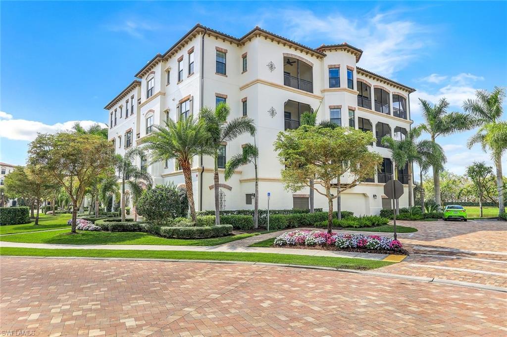 16445 Carrara Way, Unit 202 Naples, FL 34110 - Photo 27 of 35 a front view of multi story residential apartment building with yard and green space