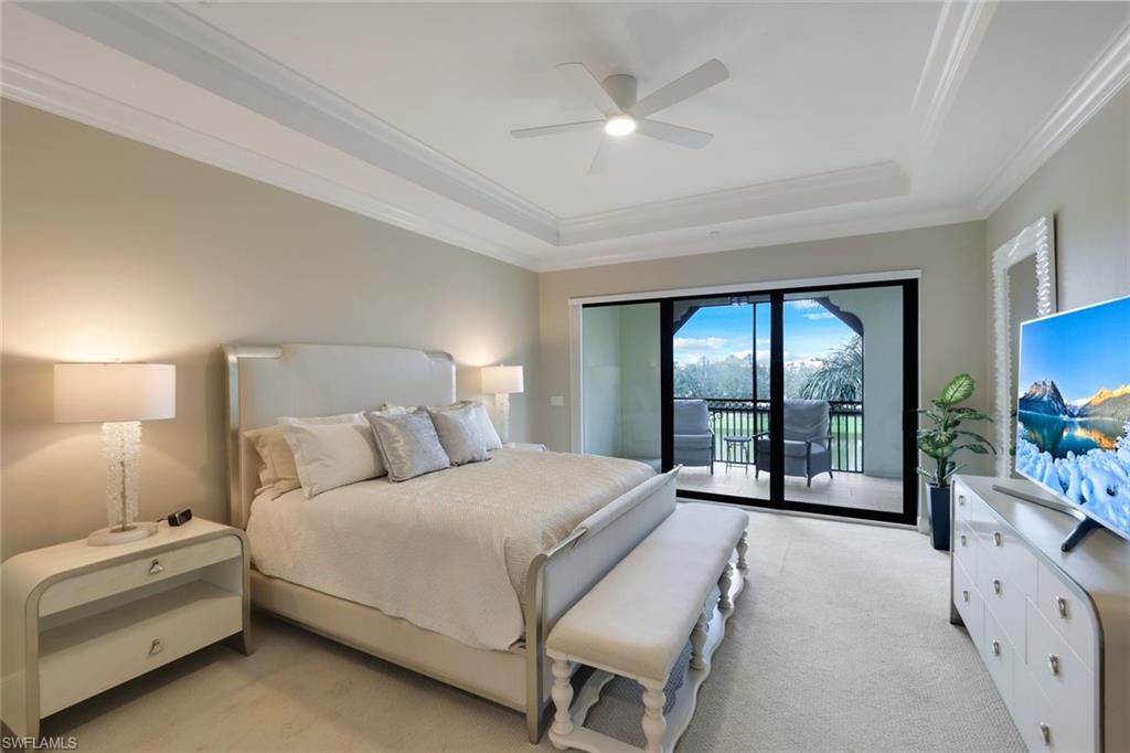 16445 Carrara Way, Unit 202 Naples, FL 34110 - Photo 9 of 35 a bedroom with a large bed and a chandelier