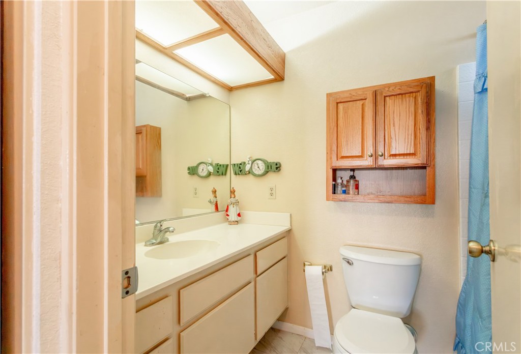 3579 Paine Drive Riverside, CA 92503 - Photo 18 of 31 a bathroom with a toilet sink a mirror and vanity