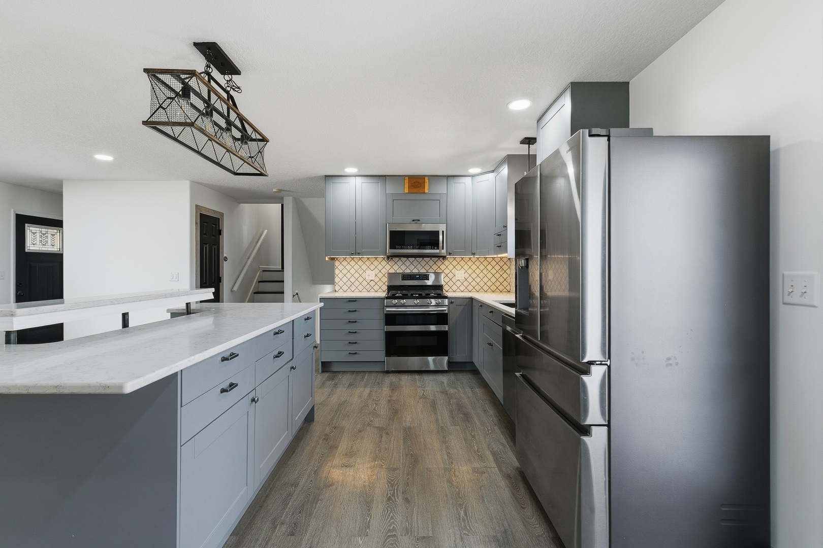 11622 27th Street West Milan, IL 61264 - Photo 6 of 49 a kitchen with kitchen island granite countertop a refrigerator a sink and white cabinets
