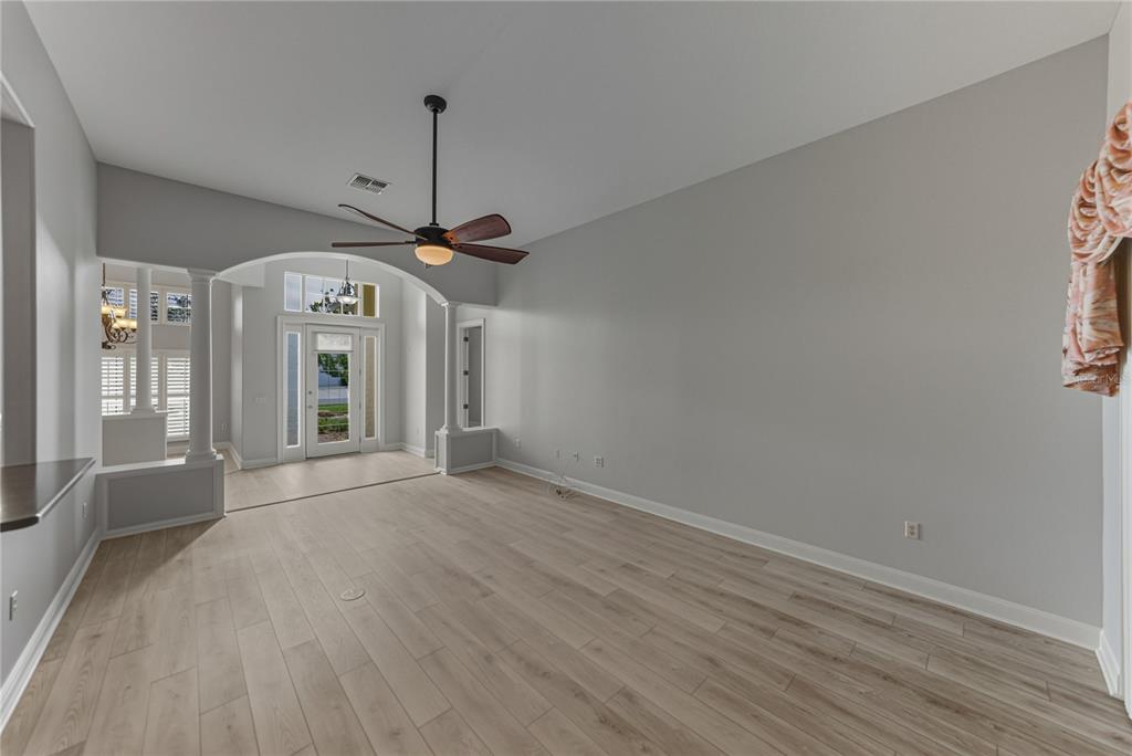 8725 Mississippi Run Spring Hill, FL 34613 - Photo 15 of 72 a view of a room with wooden floor a ceiling fan and windows