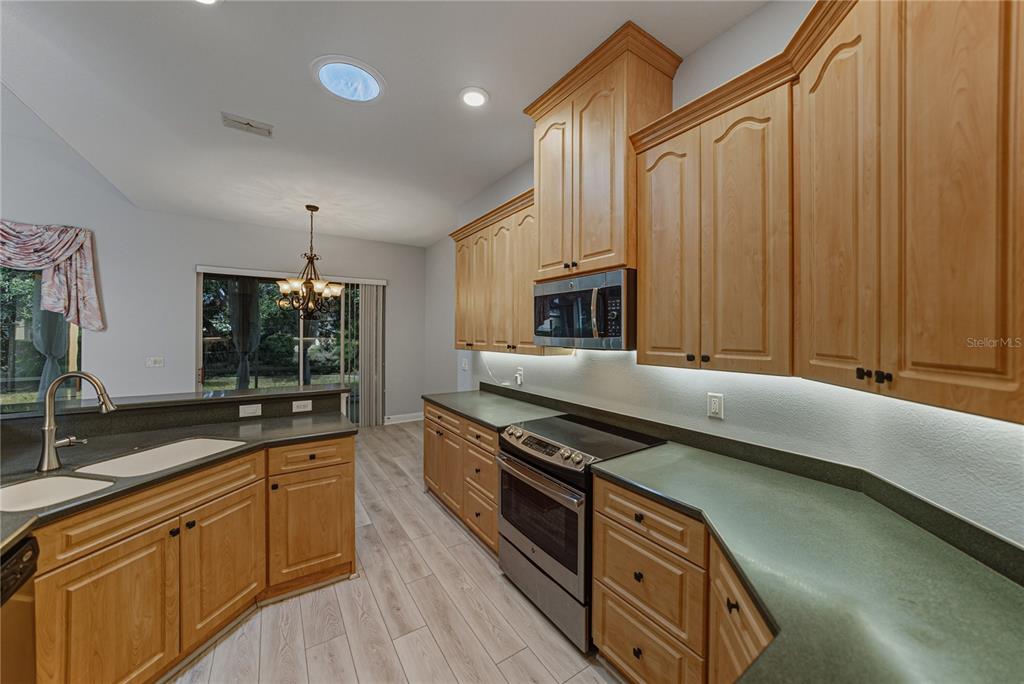 8725 Mississippi Run Spring Hill, FL 34613 - Photo 21 of 72 a kitchen with stainless steel appliances granite countertop a stove a sink and a microwave