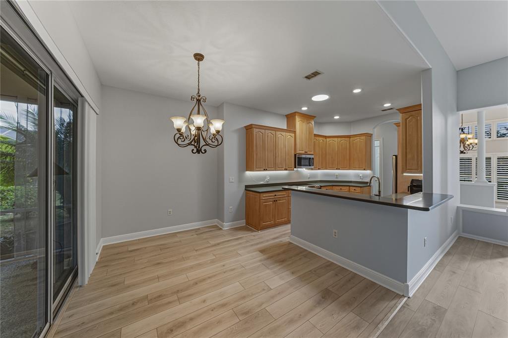 8725 Mississippi Run Spring Hill, FL 34613 - Photo 23 of 72 a kitchen with kitchen island granite countertop wooden floor stainless steel appliances and a refrigerator