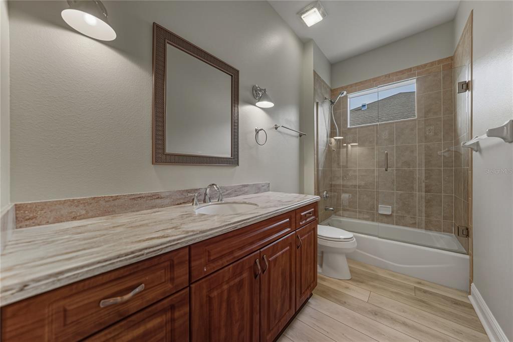 8725 Mississippi Run Spring Hill, FL 34613 - Photo 41 of 72 a bathroom with a granite countertop sink a toilet a mirror and bathtub