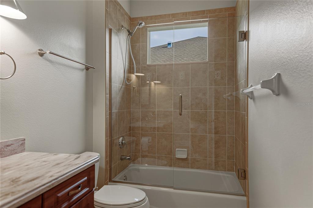 8725 Mississippi Run Spring Hill, FL 34613 - Photo 42 of 72 a bathroom with a granite countertop sink toilet and shower