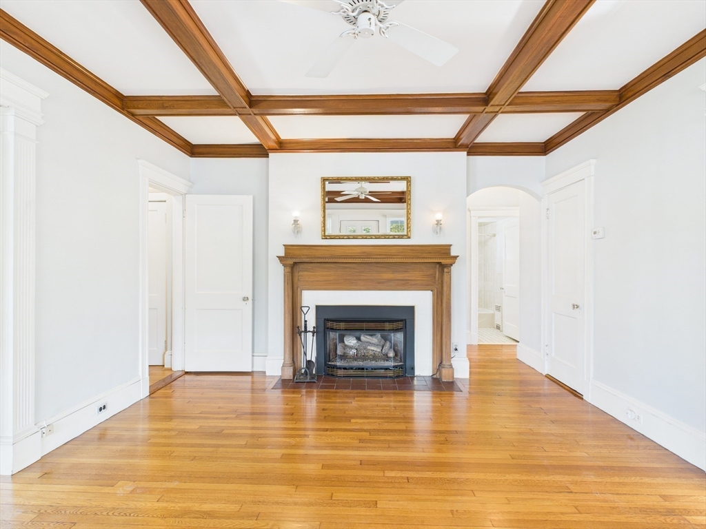 1120 Centre Street, Unit 1 Newton, MA 02459 - Photo 1 of 34 a living room with a fireplace and a wooden floor