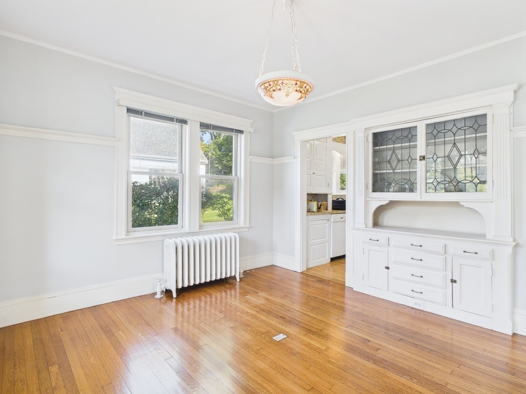 1120 Centre Street, Unit 1 Newton, MA 02459 - Photo 11 of 34 an empty room with wooden floor and windows