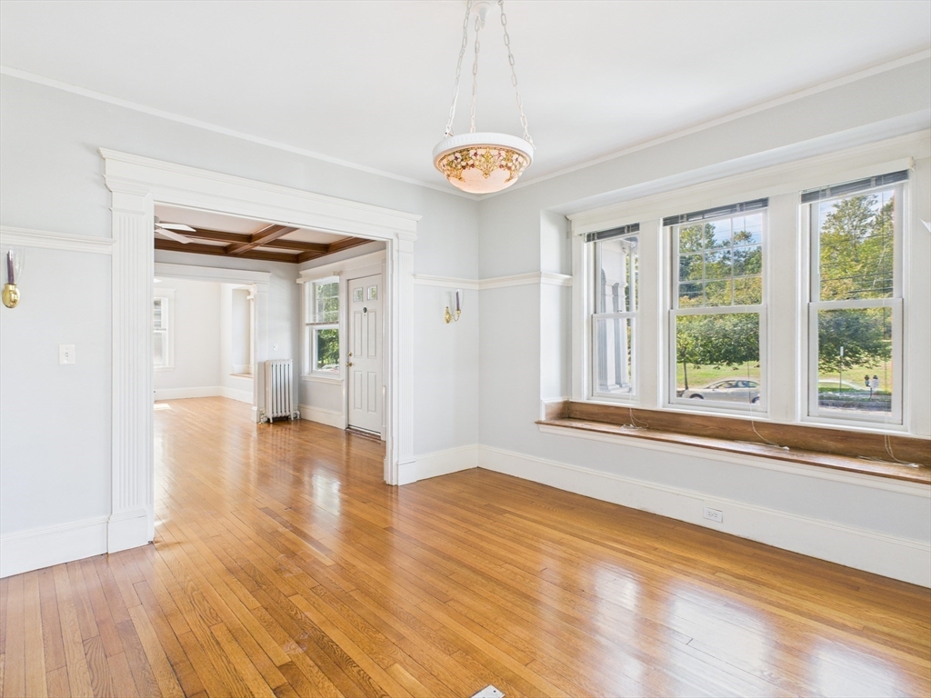 1120 Centre Street, Unit 1 Newton, MA 02459 - Photo 14 of 34 a view of an empty room with a window and wooden floor