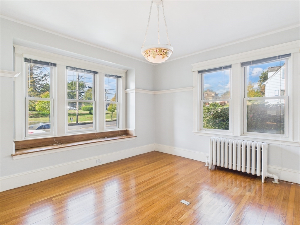 1120 Centre Street, Unit 1 Newton, MA 02459 - Photo 16 of 34 a view of an empty room with wooden floor and a window