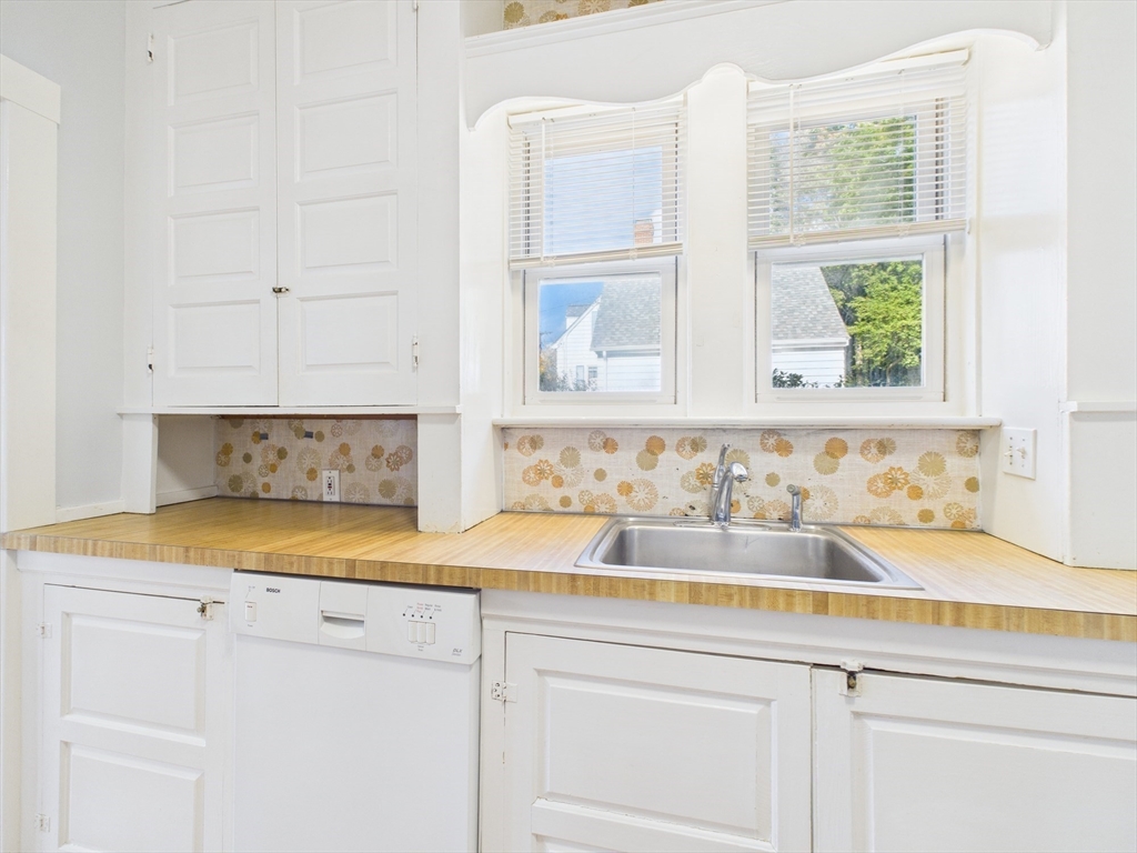 1120 Centre Street, Unit 1 Newton, MA 02459 - Photo 19 of 34 a bathroom with a granite countertop white cabinets and a sink