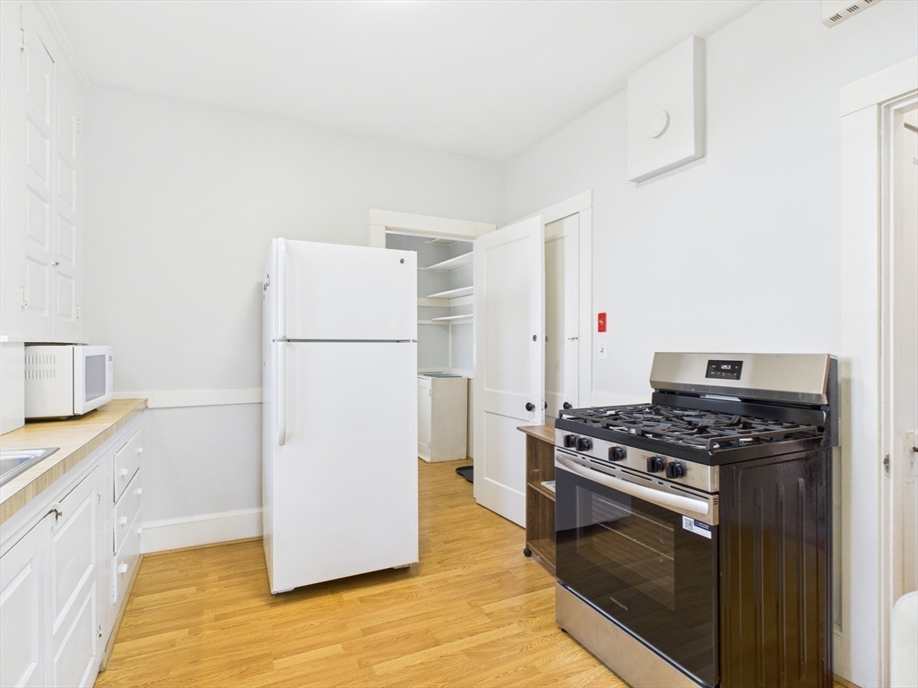 1120 Centre Street, Unit 1 Newton, MA 02459 - Photo 20 of 34 a kitchen with granite countertop a refrigerator and a stove