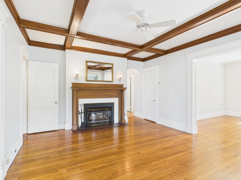 1120 Centre Street, Unit 1 Newton, MA 02459 - Photo 2 of 34 a view of an empty room with wooden floor fireplace and a window