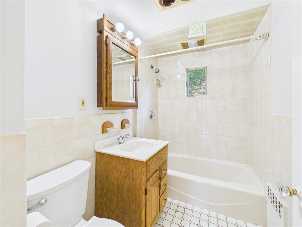1120 Centre Street, Unit 1 Newton, MA 02459 - Photo 24 of 34 a bathroom with a sink mirror toilet and bathtub