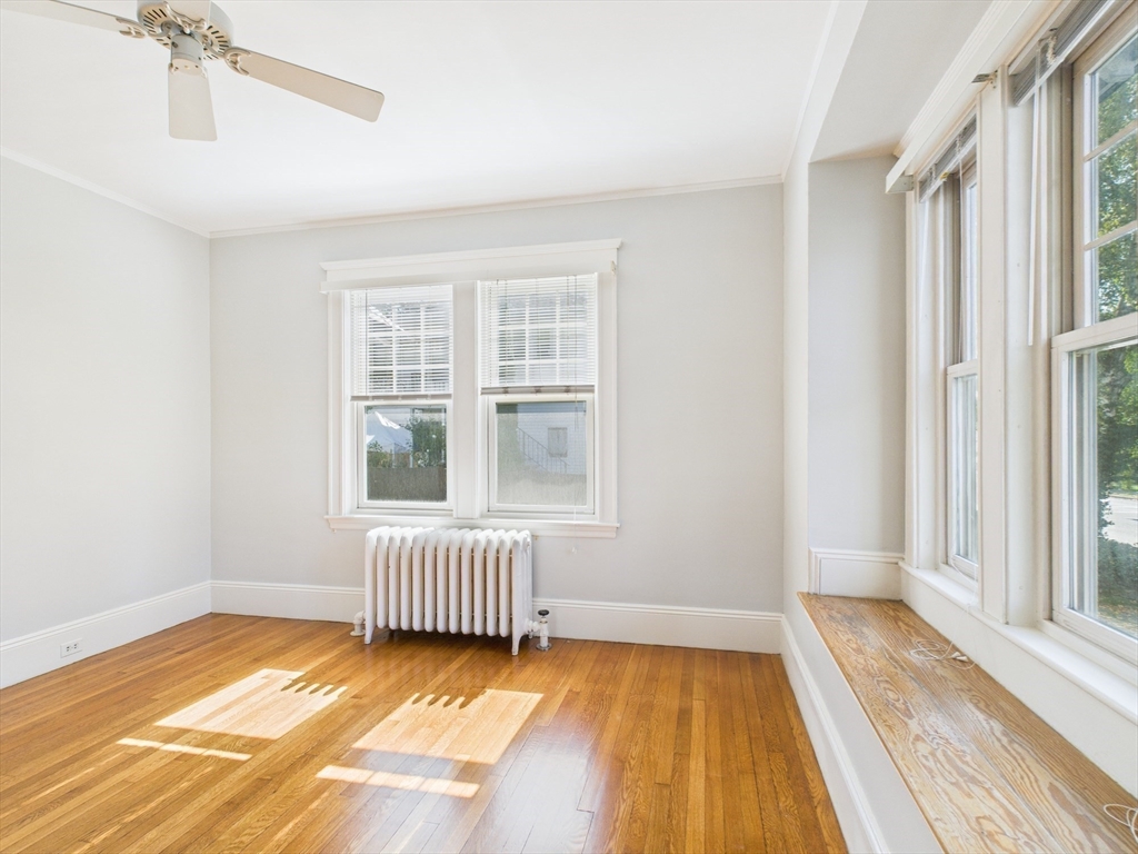 1120 Centre Street, Unit 1 Newton, MA 02459 - Photo 7 of 34 a view of an empty room with a window and wooden floor