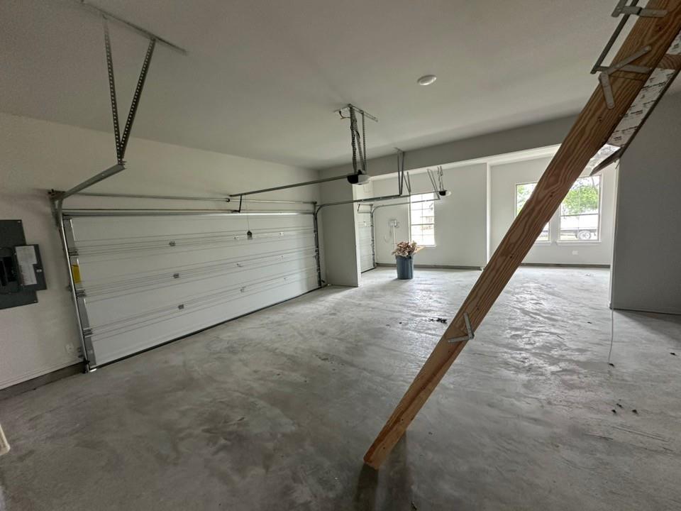 410 Cobb Road Leonard, TX 75452 - Photo 22 of 24 Spacious garage featuring a concrete floor, two white panel garage doors, and multiple windows providing natural light