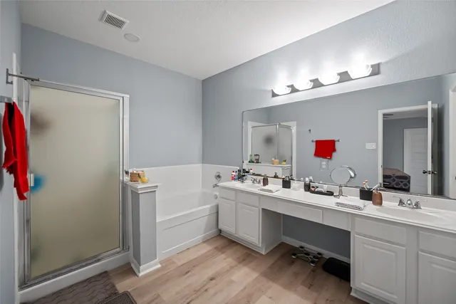 a bathroom with a double vanity sink mirror and shower