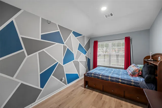 a bedroom with a bed and wooden floor