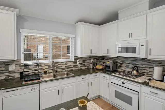 a kitchen with stainless steel appliances granite countertop a sink a stove and cabinets