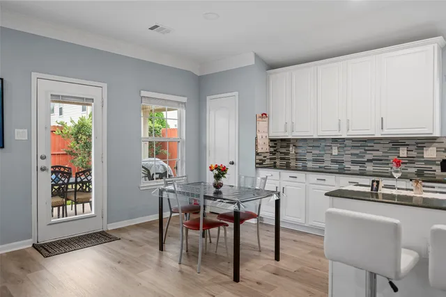 a kitchen with stainless steel appliances a table and chairs in it