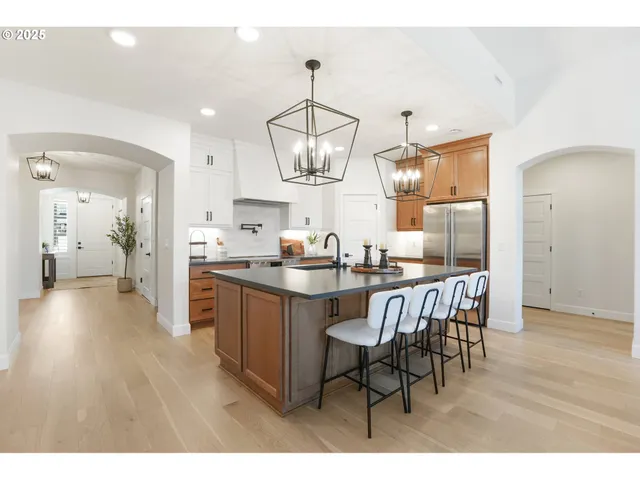 a kitchen with stainless steel appliances granite countertop a dining table chairs and granite counter tops