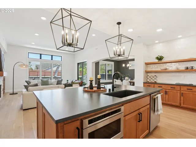 a kitchen with a sink a counter space appliances and cabinets
