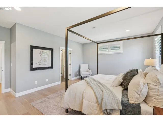 a bedroom with a bed and painting on the wall