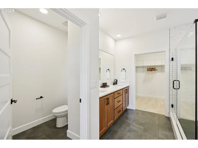 a bathroom with a sink a toilet a mirror and shower