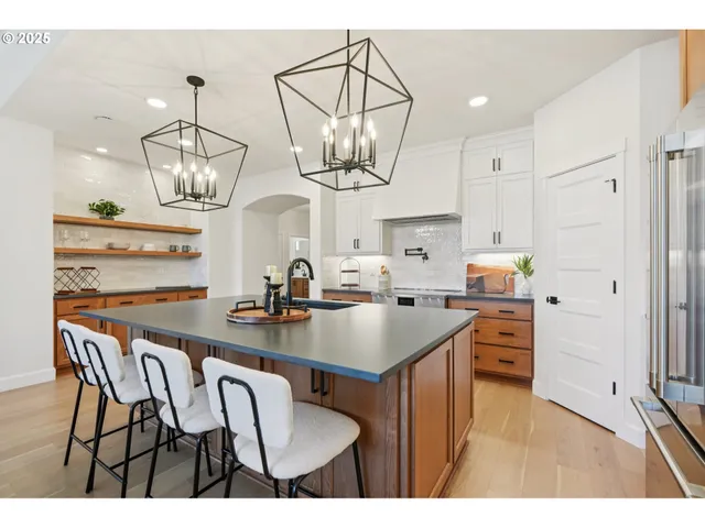 a kitchen with stainless steel appliances a table chairs and chandelier