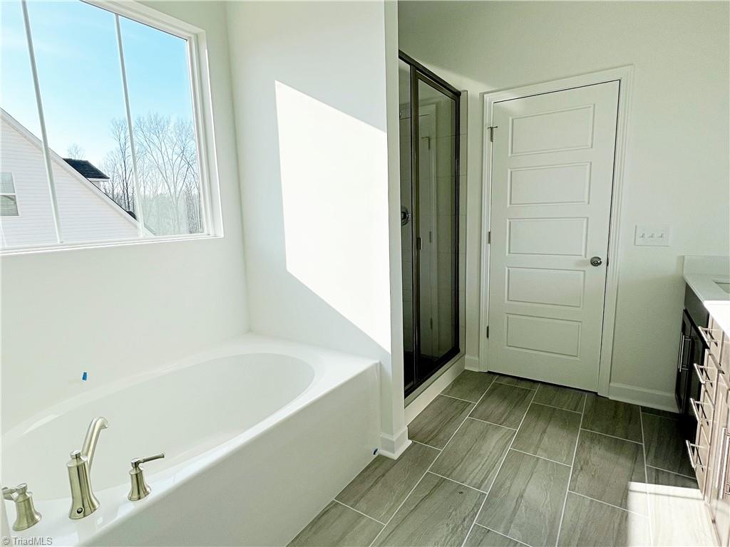 7707 Sedgewick Ridge Road Lewisville, NC 27023 - Photo 17 of 35 Primary Soaker Tub + Ceramic Tile Shower
