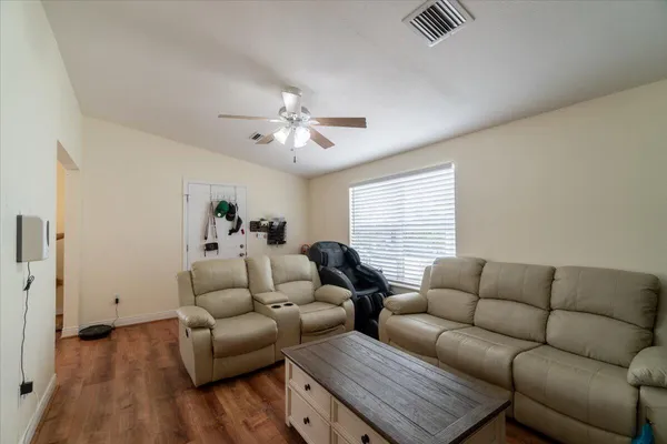 a living room with furniture and wooden floor