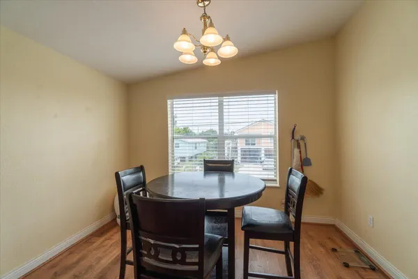 a dining room with furniture a chandelier and wooden floor