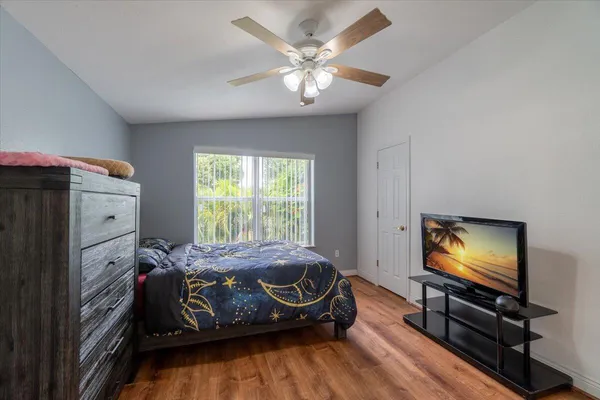 a bedroom with a bed and a flat tv screen on the dresser