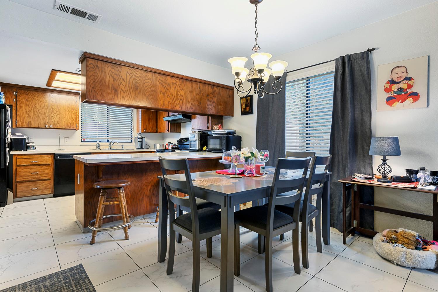 1592 North Ferger Avenue Fresno, CA 93728 - Photo 11 of 30 a dining room filled a chandelier and kitchen view