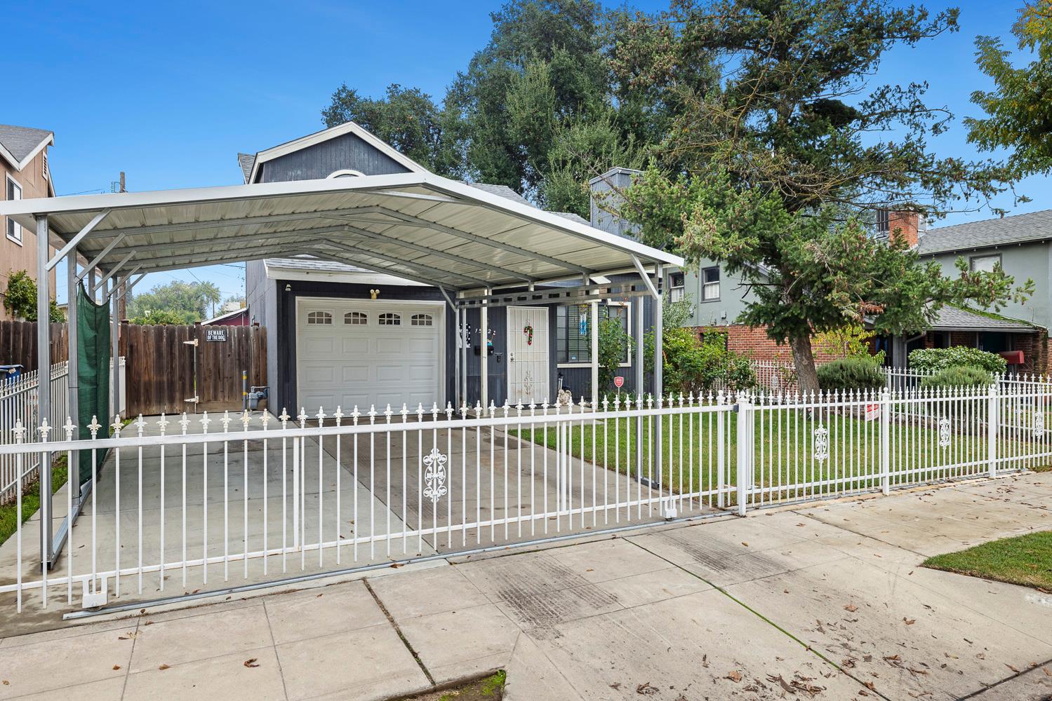1592 North Ferger Avenue Fresno, CA 93728 - Photo 4 of 30 a view of a house with a small yard and a large tree