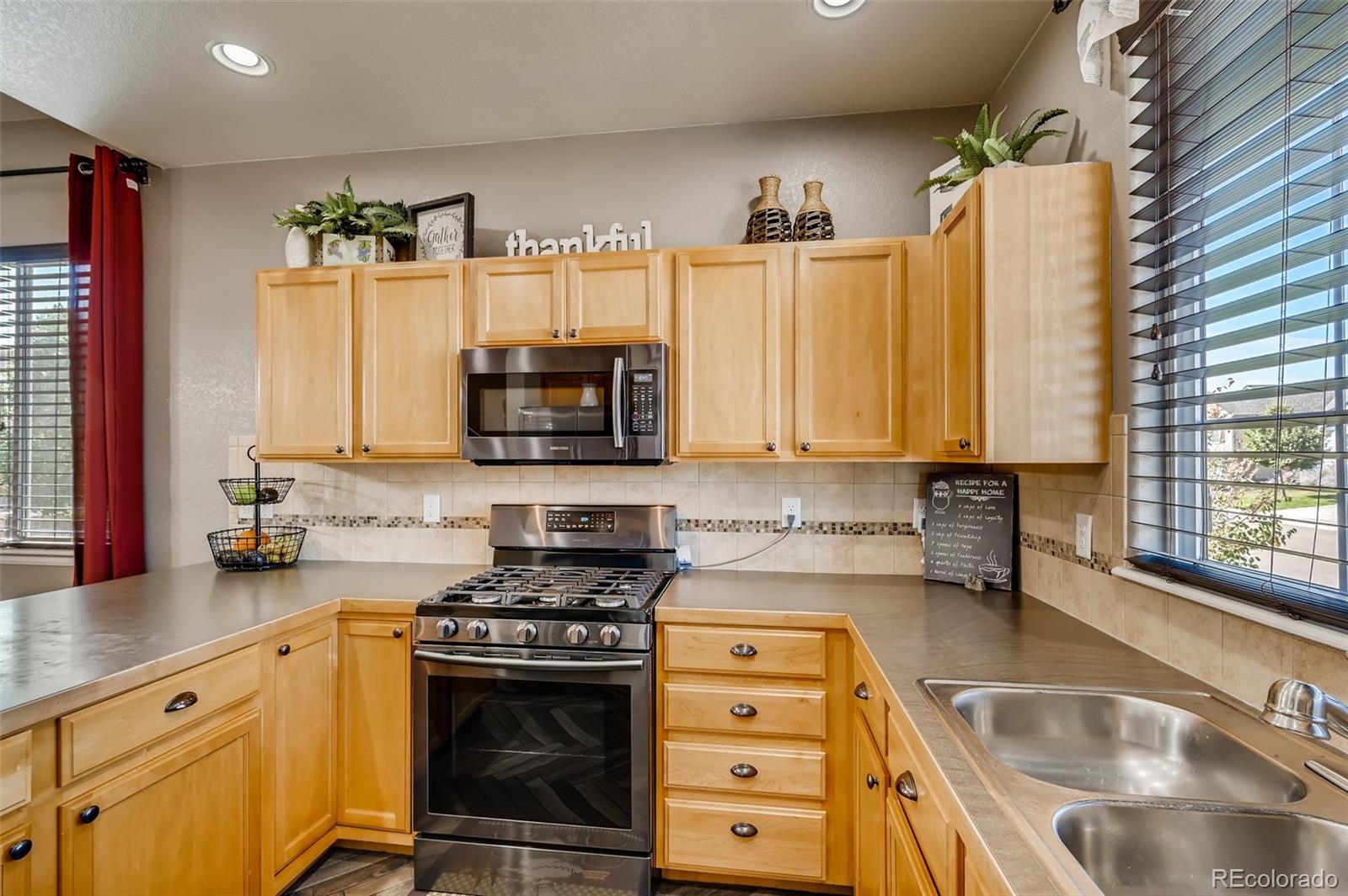 465 Territory Lane Johnstown, CO 80534 - Photo 6 of 24 a kitchen with stainless steel appliances a stove a sink a microwave a refrigerator and cabinets