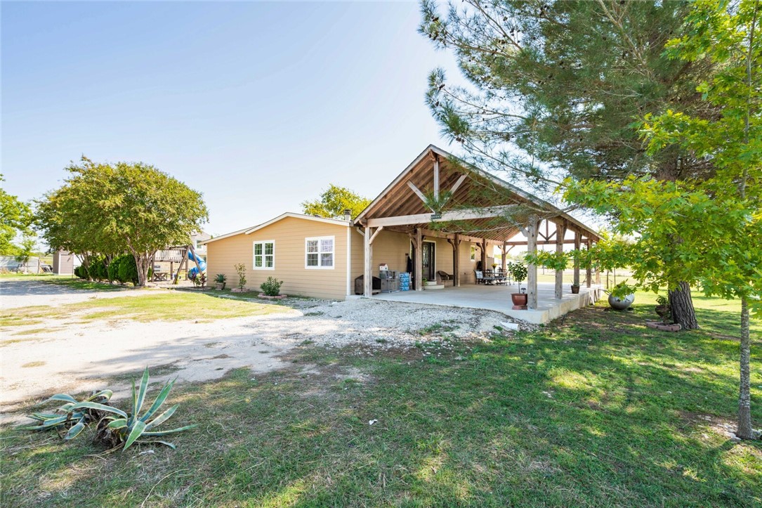 a front view of a house with a yard and trees