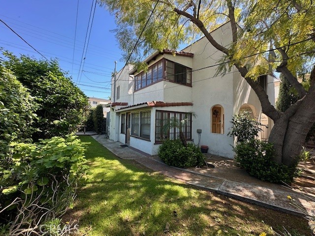 1028 San Rafael Avenue Glendale, CA 91202 - Photo 12 of 17 a view of a white house next to a yard with plants and trees