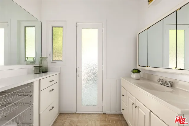 a spacious bathroom with double vanity and a mirror
