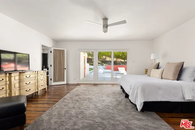 a spacious bedroom with a large bed and a flat screen tv